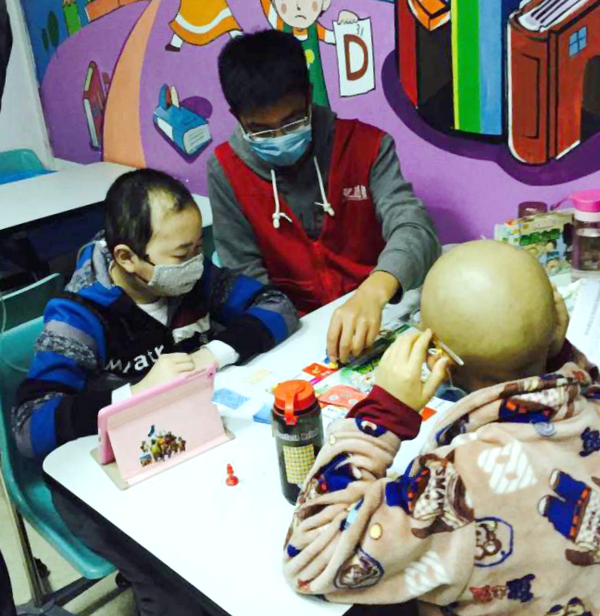 1460523463108147.png 图为志愿者陪儿童患者玩“大富翁”游戏 摄影:高瑞雪_副本.png